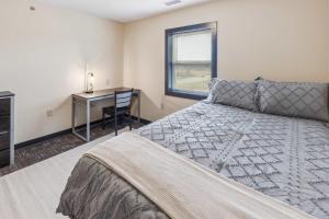 a bedroom with a bed and a desk and a window at Recharge Right Bright Space with Modern Touches in Mansfield