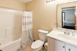 a bathroom with a toilet and a sink and a mirror at Recharge Right Bright Space with Modern Touches in Mansfield +23 photos