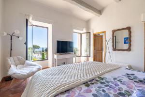 a bedroom with a bed and a tv and a window at Villa Flore - Panoramic Sea View by Halldis in Vallauris +31 photos