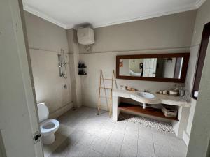 a bathroom with a sink and a toilet and a mirror at Balieys Villa, Tranquil Hideaway in Central Canggu in Canggu
