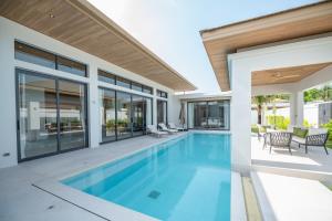ein Bild eines Schwimmbads in einem Haus in der Unterkunft Mouana Breeze Maikhao 3-bedroom Pool Villa in Mai Khao Beach