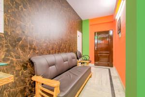 a room with a couch and a wall with green and orange at Super Hotel O Kamini in Patna
