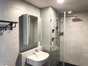 Un baño con lavabo y ducha de cristal. en 亲子出游首选 步行到码 Suria 家庭房带设施齐全厨房 Perfect for Family Getaways Walk to Jetty & Suria Family Room Full Kitchen, en Kota Kinabalu 63 fotos más