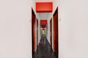 an empty hallway with red walls and a long corridor at Hotel O East Fort in Trivandrum +25 photos
