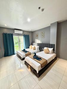 two beds in a large room with blue curtains at Miami Beach Hotel Boracay in Boracay +42 photos