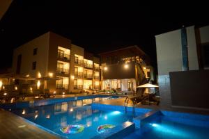 a large swimming pool in front of a building at night at AIDEN HOMES AND APARTMENTS HOTEl in Koforidua