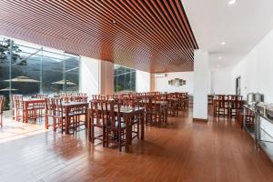 a restaurant with wooden tables and chairs and windows at Boya International Resort Luang Prabang in Luang Prabang