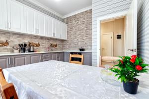 アスタナにあるКвартира нетの白いテーブルと植物が並ぶキッチン