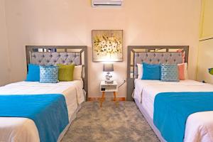 two beds in a room with blue and white at San Jerónimo Casa Oaxaca in Oaxaca City