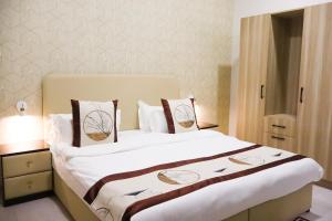 a bedroom with a large bed with two pillows at AL MARSA HOTEL APARTMENTS in Khor Fakkan