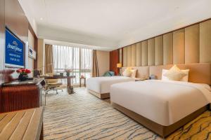 Postel nebo postele na pokoji v ubytování Kangda Howard Johnson Hotel Qingdao