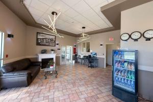 a living room with a couch and a refrigerator at Super 8 by Wyndham Medicine Hat AB in Medicine Hat