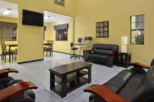 a waiting room with couches and a table and chairs at Super 8 by Wyndham San Antonio/Riverwalk Area in San Antonio