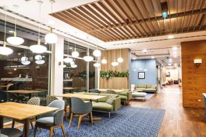 a dining room with tables and chairs and lights at Hampton by Hilton Świnoujscie in Świnoujście +74 photos
