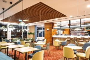 a restaurant with tables and chairs and a bar at Hampton by Hilton Świnoujscie in Świnoujście