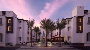 库卡蒙格牧场Sanctity Hotel Rancho Cucamonga, Tapestry Collection Hilton的一排棕榈树白色的建筑