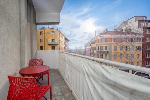 a balcony with two chairs and a table on a building at Flower Apartment - Affitti Brevi Italia in Trieste