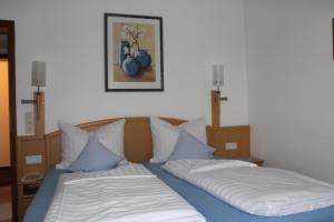 two twin beds in a room with a picture on the wall at Erwachsenen Aparthotel DER WIESERHOF Wunderschöne Einzellage in Bad Füssing