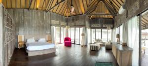 a bedroom with a bed and a couch in a room at Mega Resort Karimunjawa in Karimunjawa +94 photos