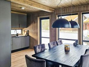 eine Küche und ein Esszimmer mit Tisch und Stühlen in der Unterkunft 11 person holiday home in Hornnes in Hornnes