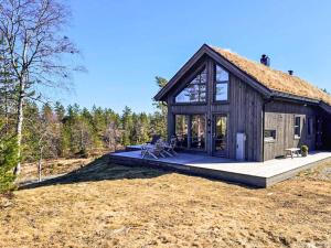 eine große Holzhütte mit einem großen Fenster in der Unterkunft 11 person holiday home in Hornnes in Hornnes