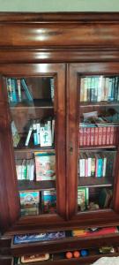 a wooden book cabinet filled with lots of books at Maison avec piscine et jardin d'arbres fruitiers in Cours-de-Pile