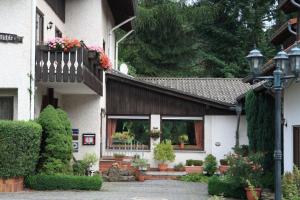 a house with a balcony with flowers on it at Rhönhotel Alte Mühle in Weyhers +23 photos