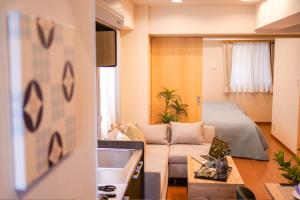 a living room with a couch and a bed at Residence Hotel Ryogoku in Tokyo