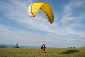 a person is flying a kite in a field at Rhönhotel Alte Mühle in Weyhers
