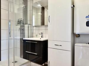 une salle de bain blanche avec une douche et un lavabo dans l'établissement Le Yearling, à Deauville