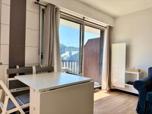 une petite pièce avec une table et une grande fenêtre dans l'établissement Le Yearling, à Deauville 3 autres photos