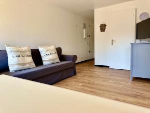 un salon avec un canapé et une télévision dans l'établissement Le Yearling, à Deauville