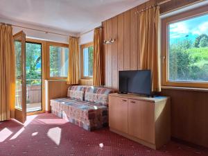 a living room with a couch and a flat screen tv at Residence Rastbichl - Apartments & Indoor-Pool in Maranza +22 photos