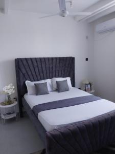 a bedroom with a large bed with a black headboard at The Residence Beach Apt Nyali in Mombasa +29 photos