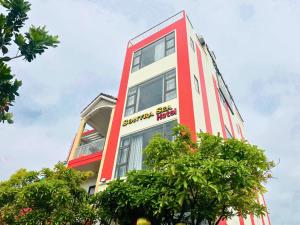 a red and white building with trees in front of it at Sontra Sea Hotel in Danang