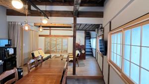 a dining room with a long table and a couch at 城下町小諸の古民家 - 町屋の隠れ宿-椛庵 Japanese old folk house - momijian in Komoro