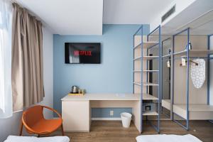 a room with a desk and a book shelf at Graffiti Hotel Rooftop - Central Location in Bucharest