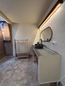 een badkamer met een wastafel, een spiegel en een stoel bij Bale Baba private pool villa in Gili Air
