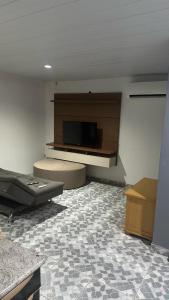 a living room with a flat screen tv on the wall at Quarto de vila na Urca in Rio de Janeiro