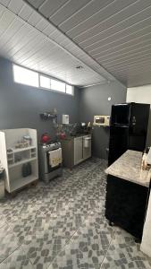 a large room with a kitchen with appliances in it at Quarto de vila na Urca in Rio de Janeiro +8 photos