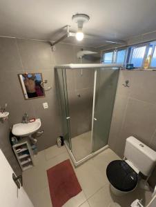 a bathroom with a shower and a toilet and a sink at Quarto de vila na Urca in Rio de Janeiro