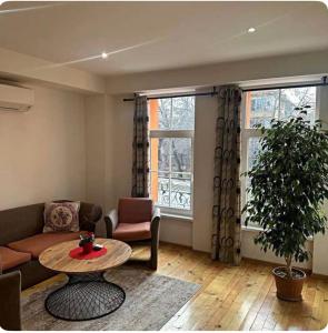 ein Wohnzimmer mit Sofa und Tisch in der Unterkunft Center Apartments The Quiet Luxury 3 in Plowdiw