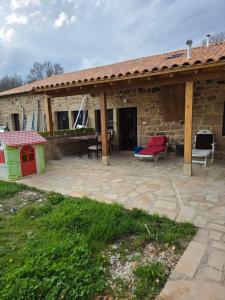 a stone house with a patio with a roof at La Casa De Los NAVARONES in Vilviestre de los Nabos