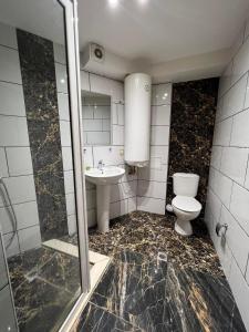 ein Badezimmer mit Toilette und Waschbecken in der Unterkunft Center Apartments The Quiet Luxury 3 in Plowdiw