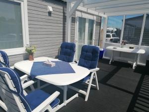 a patio with a table and chairs on a deck at Urlaub im Ibiza-Mobilheim an der Ostsee in Hasselberg