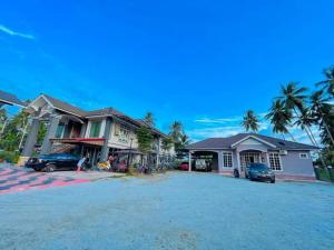 a group of houses with cars parked in a driveway at Airport Riverside Roomstay & Homestay in Kota Bharu