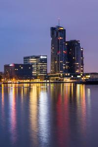 un perfil urbano por la noche con una gran masa de agua en NORDA Apartamenty SEA TOWERS Gdynia, en Gdynia