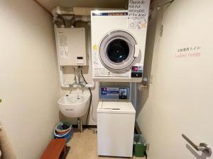 a bathroom with a washing machine and a toilet at Guesthouse Otaru Wanokaze single room / Vacation STAY 32196 in Otaru