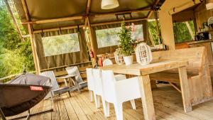 a kitchen and dining area of a trailer with a table and chairs at Lodge Holidays - Camping Delle Rose in Case Romagnoni