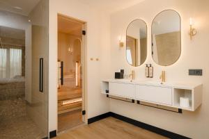 a bathroom with a sink and two mirrors at Hotel Philippe Suites I Kloeg Collection in Philippine +59 photos